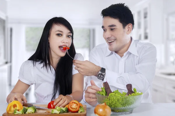 Couple cook and eat salad