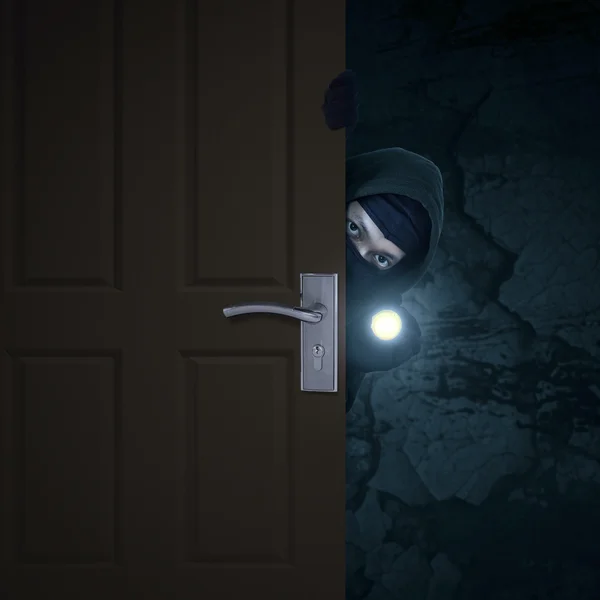 Robber sneaking through door