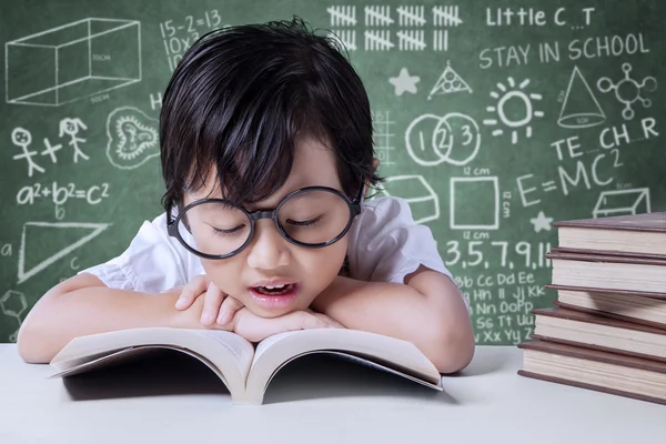 Elementary school student reads textbooks in class