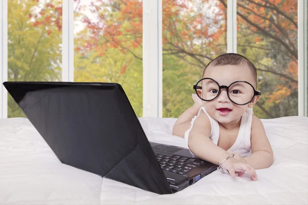 Cheerful baby and laughing with laptop