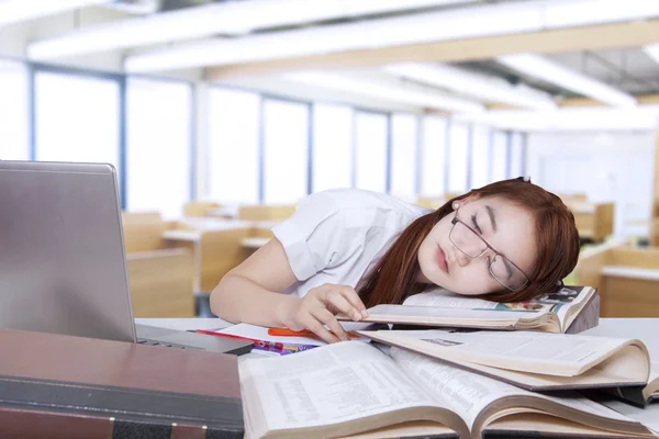 Student napping in class and lean on book