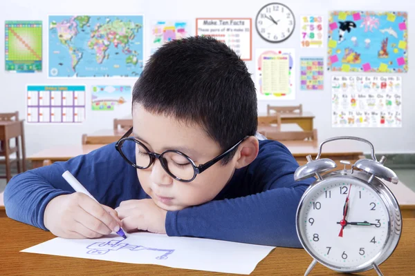 Clever schoolboy studying in the classroom