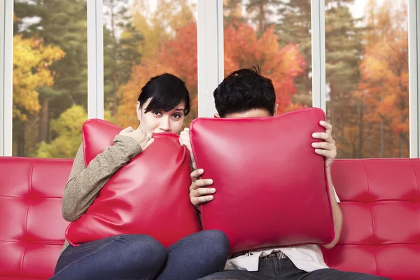 Couple watching horror movie at tv