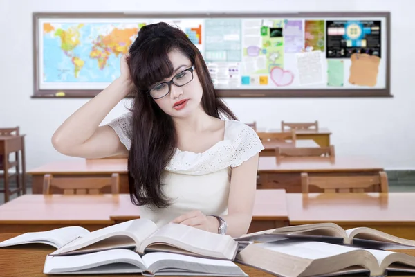 Stressful female learner studying in the classroom