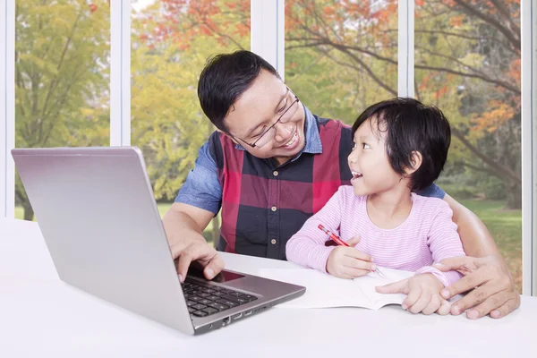 Father helps his female kid learning at home