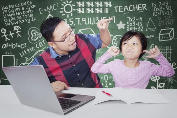 Teacher scolding his student in the class