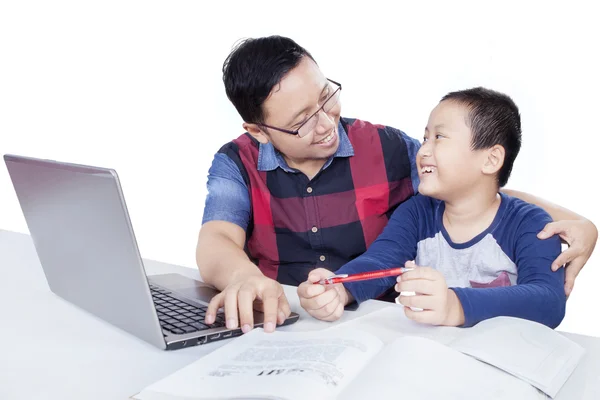 Little boy talking with dad while studying