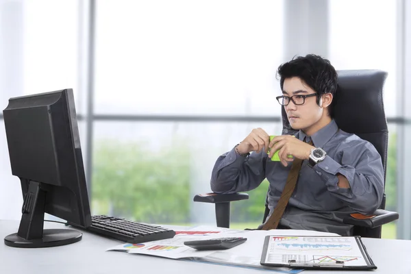 Manager drinking coffee in the office