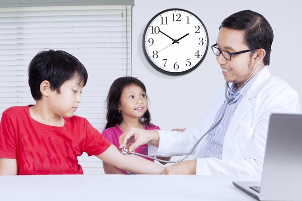 Male doctor checking the child heartbeat