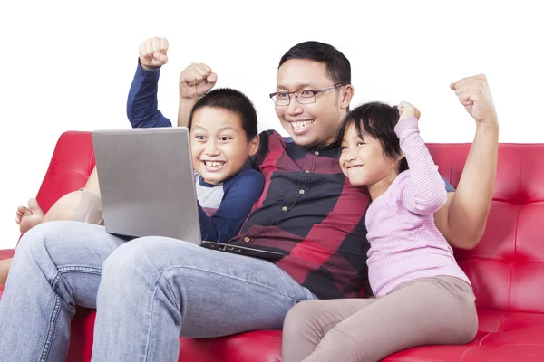 Man playing games with his children on laptop