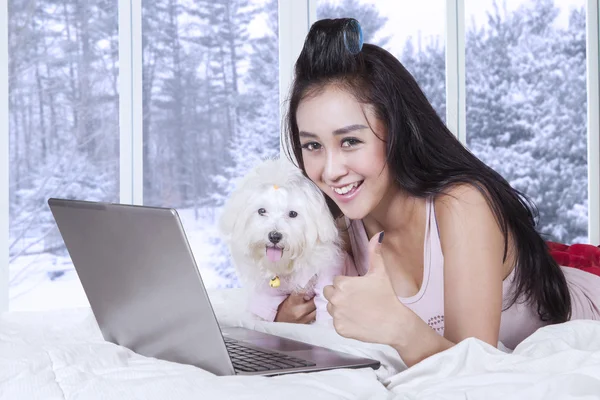 Cute woman with puppy showing thumb up