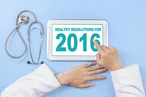 Doctor writes healthy resolution for 2016 on tablet