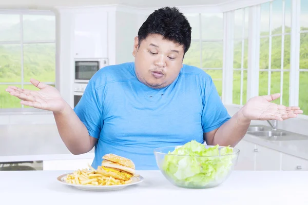 Confused fat person choosing salad or hamburger