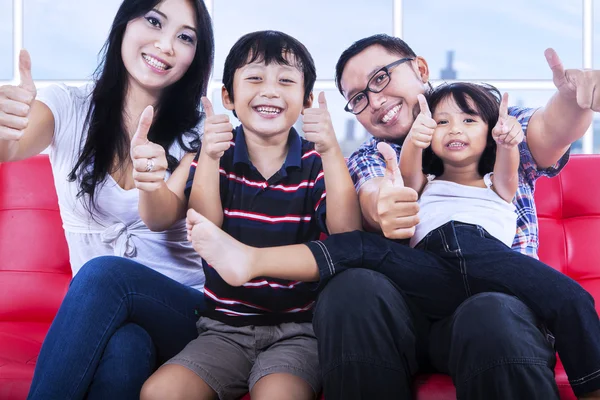 Happy family showing thumbs up