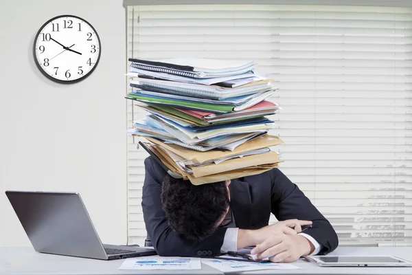 Tired employee works overtime with paperwork