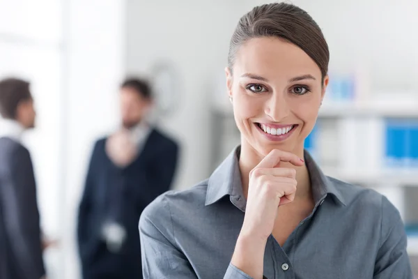 Confident businesswoman with hand on chin