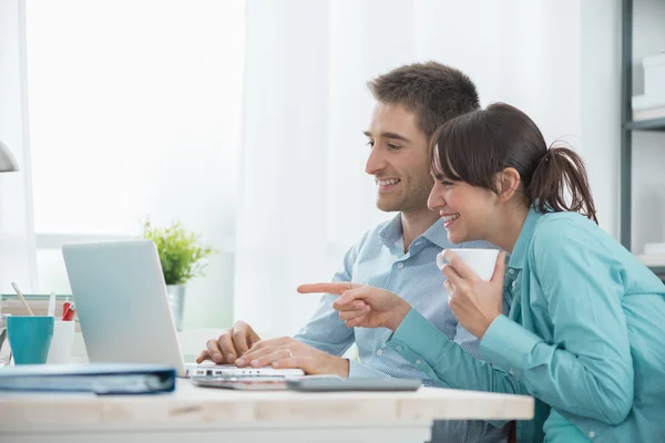 Smiling couple  networking with their laptop