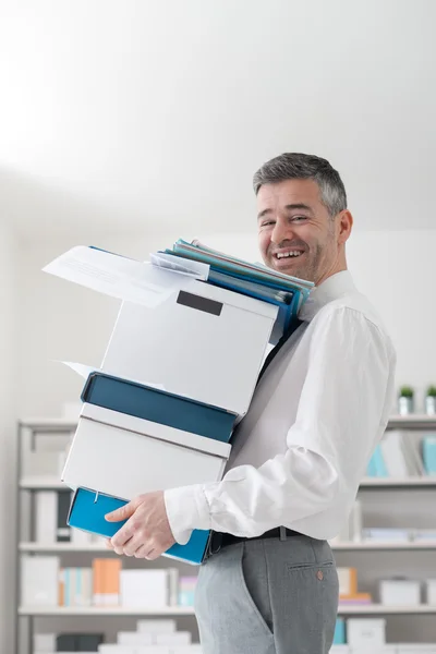 Happy office worker carrying boxes