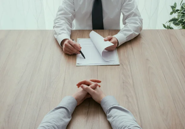 Examiner reading a resume during a job interview