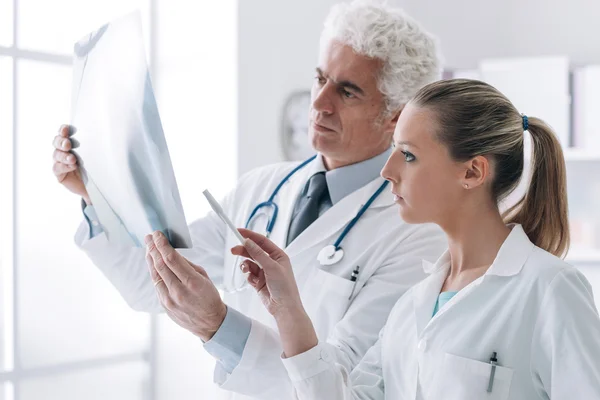 Radiologist checking an x-ray with his assistant