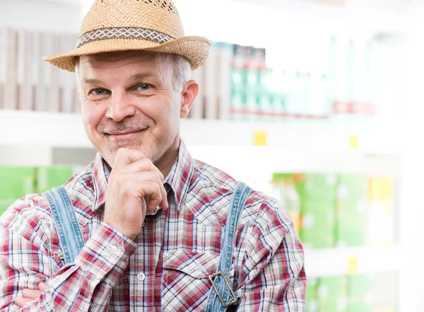 Farmer at supermarket with hand on chin