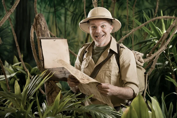 Vintage explorer in jungle with map
