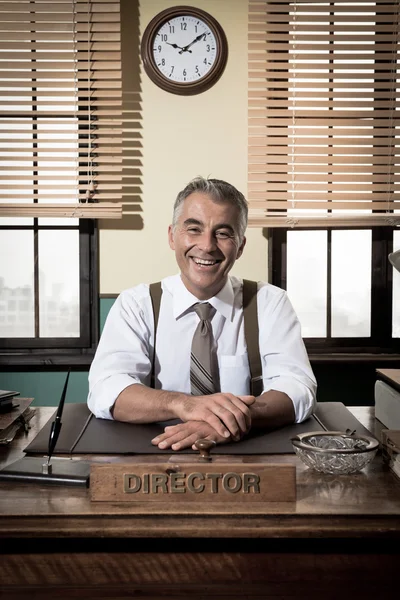 Director sitting at office desk