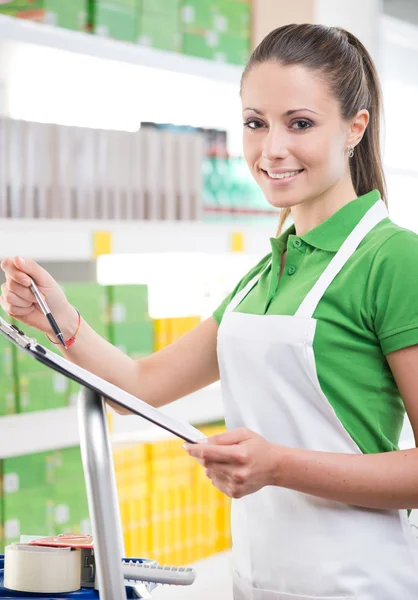 Female sales clerk holding clipboard