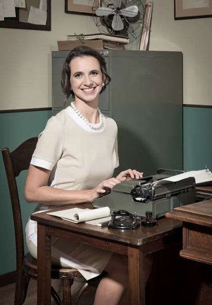 Secretary typing on vintage typewriter