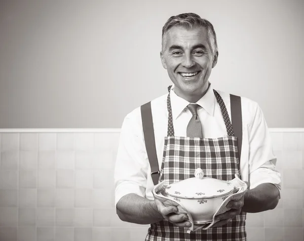 Smiling man in apron serving dinner