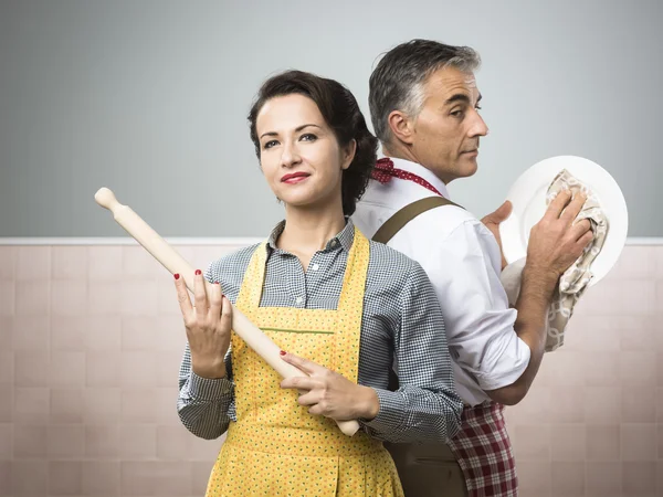 Woman with rolling pin watching husband