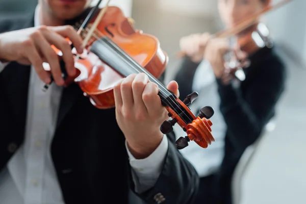 Two violinists performing together