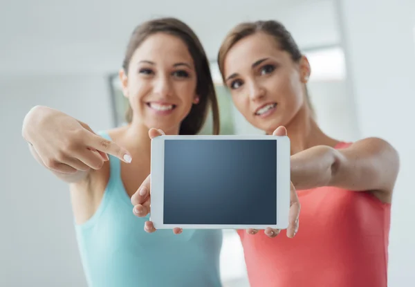 Cheerful girls showing a tablet