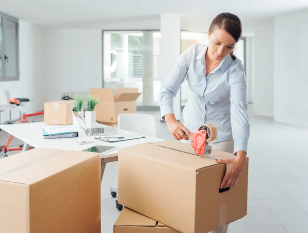 Woman taping up a cardboard box