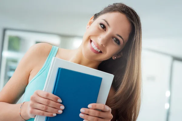 Smiling student holding books