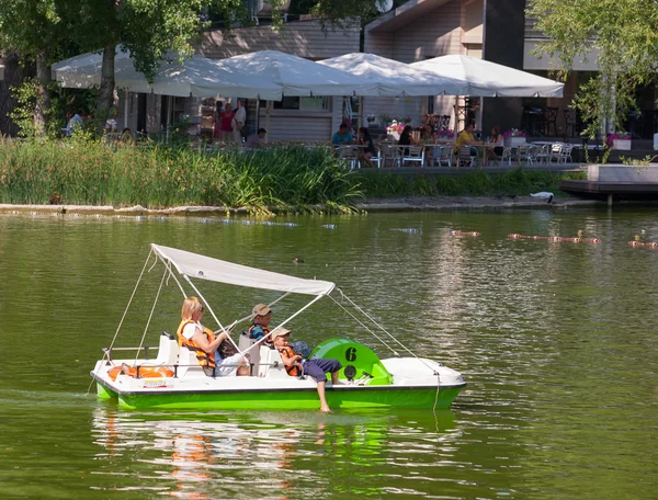 The woman and two boys riding on a catamaran