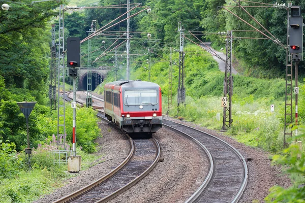 Train driving through woods near river Moselle in Germany