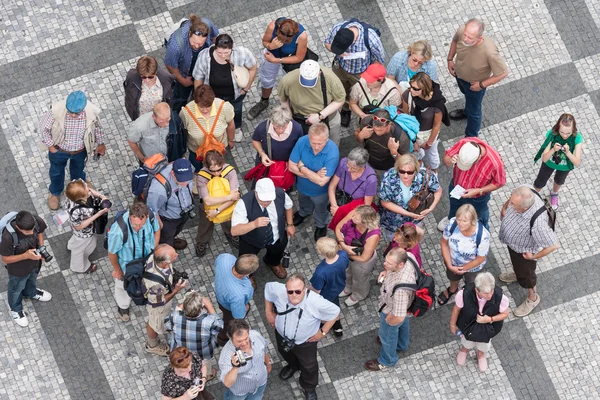 Top view group of unknown tourists waiting at the old town square in the center of Prague, Czech Republic