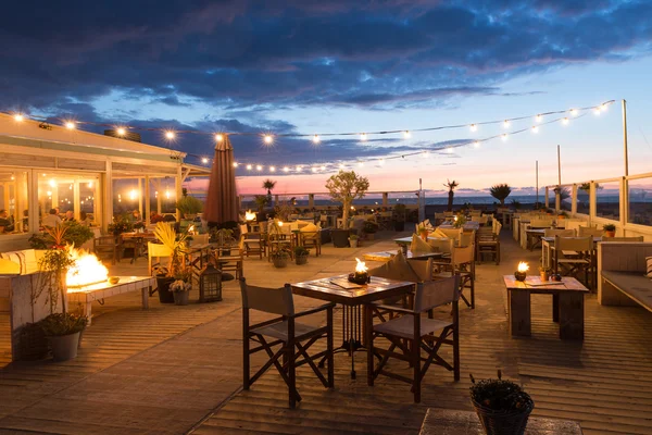 Sea sunset with people in a restaurant along the Dutch coast of Scheveningen