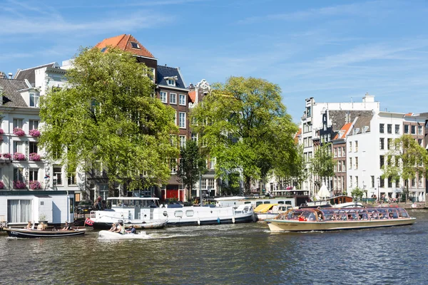 Canal with cruise ship downtown in Amsterdam, The Netherlands