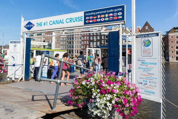 Tourists buying tickets at departure place of Amsterdam canal cruises