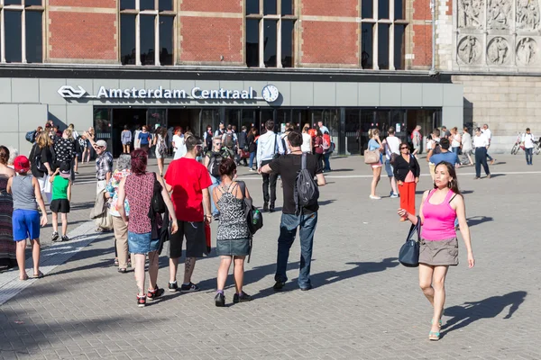 Tourists walking in front of the central station of Amsterdam