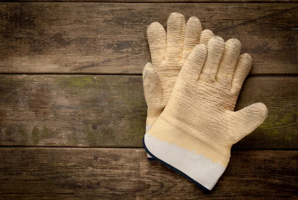 Working gloves on old wooden background