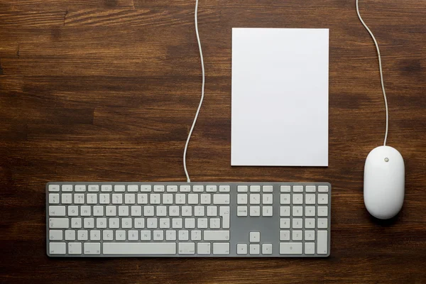 Keyboard and mouse on wooden background