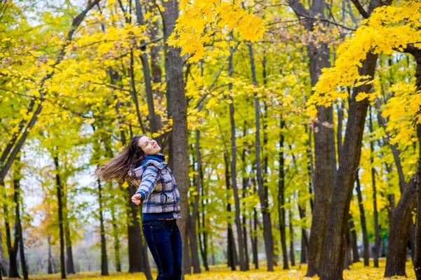 Girl spinning in autumn park fun