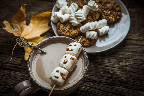 Hot cocoa with marshmallows on the old wooden boards.