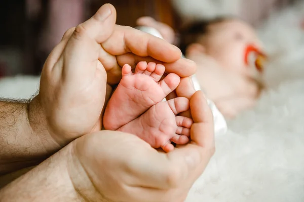 The feet of the newborn in the hands of the Pope