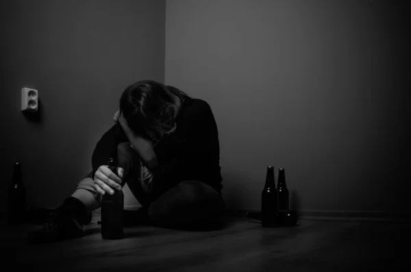 Sad woman drinking alcohol, black and white