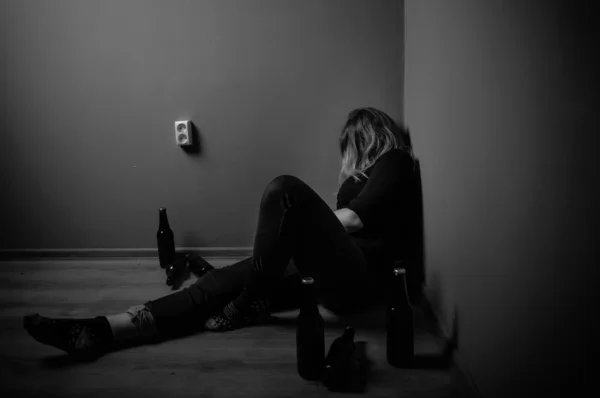 Sad woman drinking alcohol, black and white