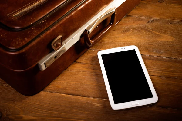 Suitcase and old camera, tablet, phone and a cup of coffee.